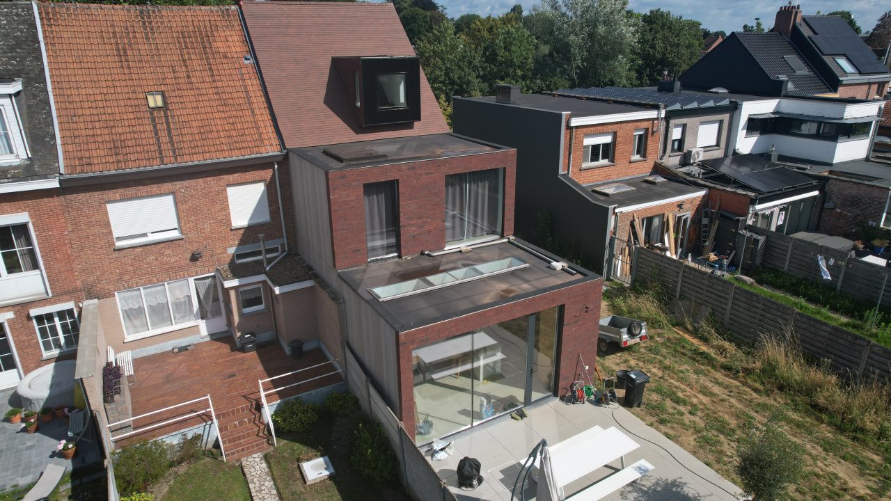 Rear view of the timber-frame extension in Belgium, highlighting the glass-walled ground floor and rooftop terrace.