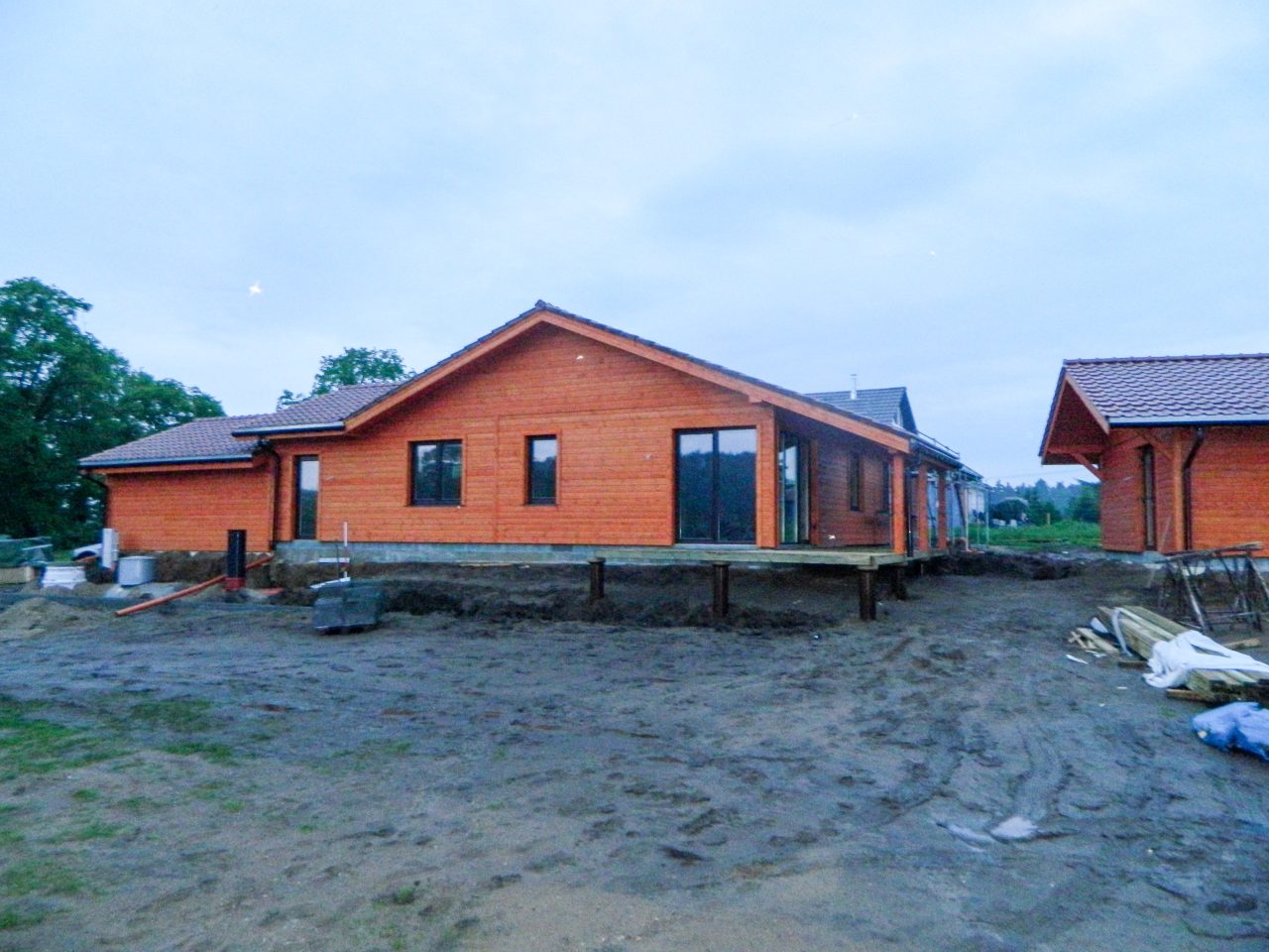 Front and side view of a factory-built timber house during final stages of installation.