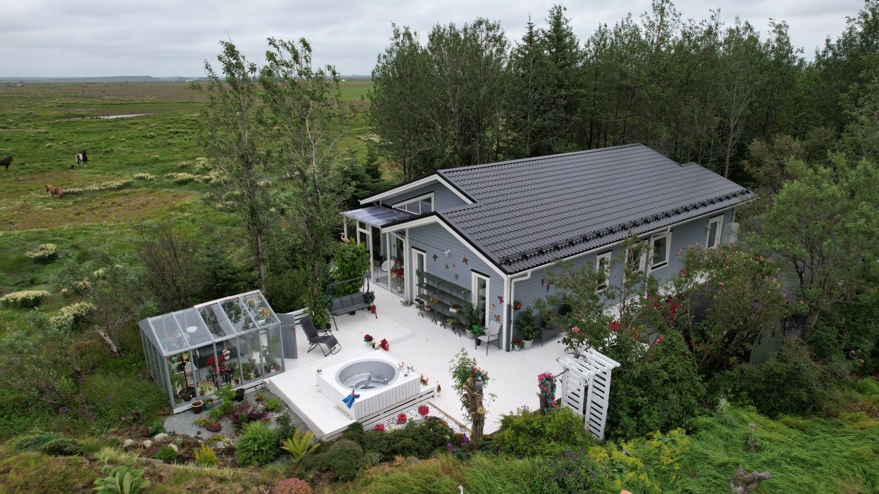 Aerial view of the Lagan house in Iceland with a large terrace, hot tub area, and landscaped garden.
