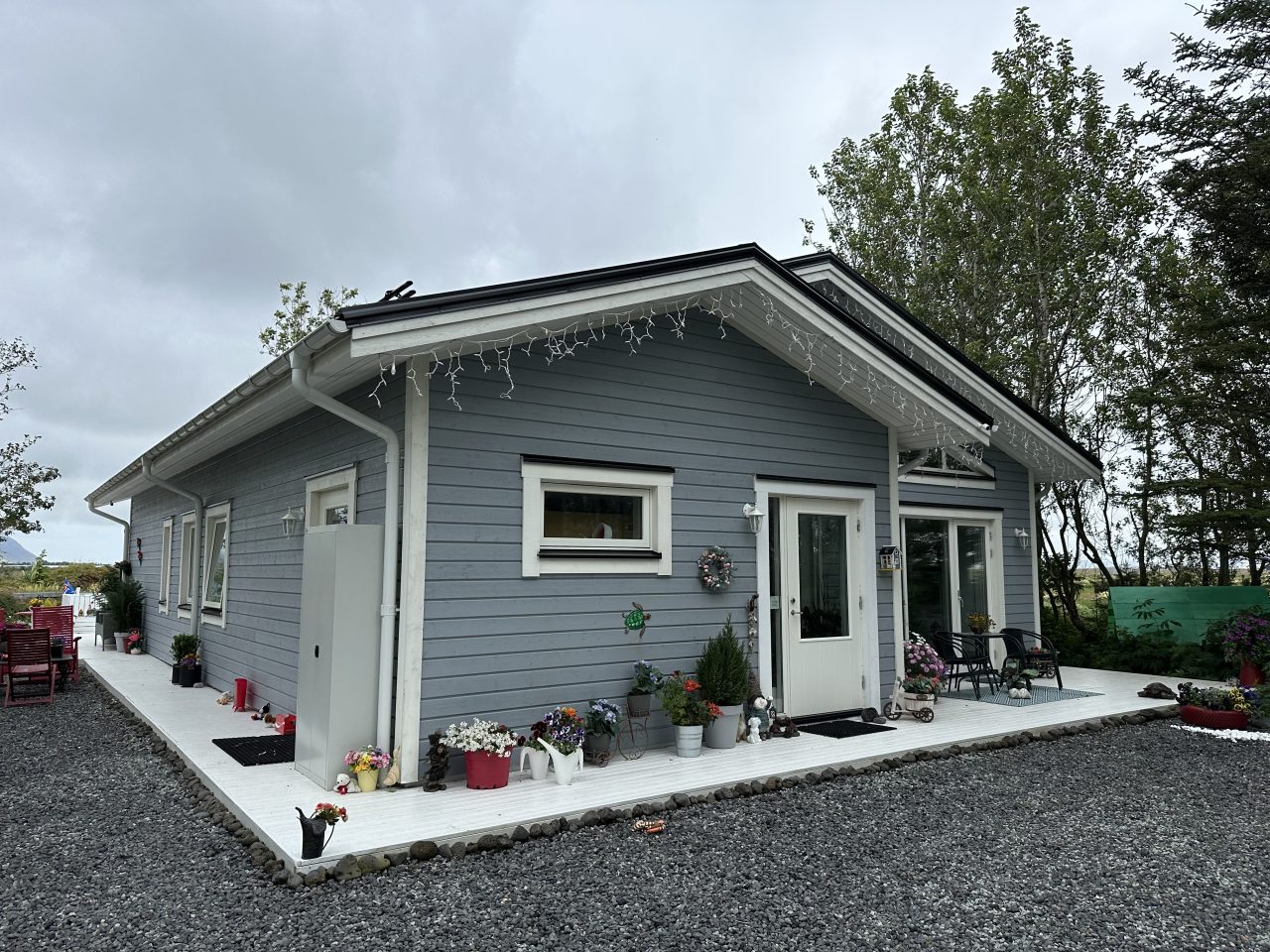 Side entrance of the Lagan house in Iceland showing grey timber cladding and a sheltered doorway.