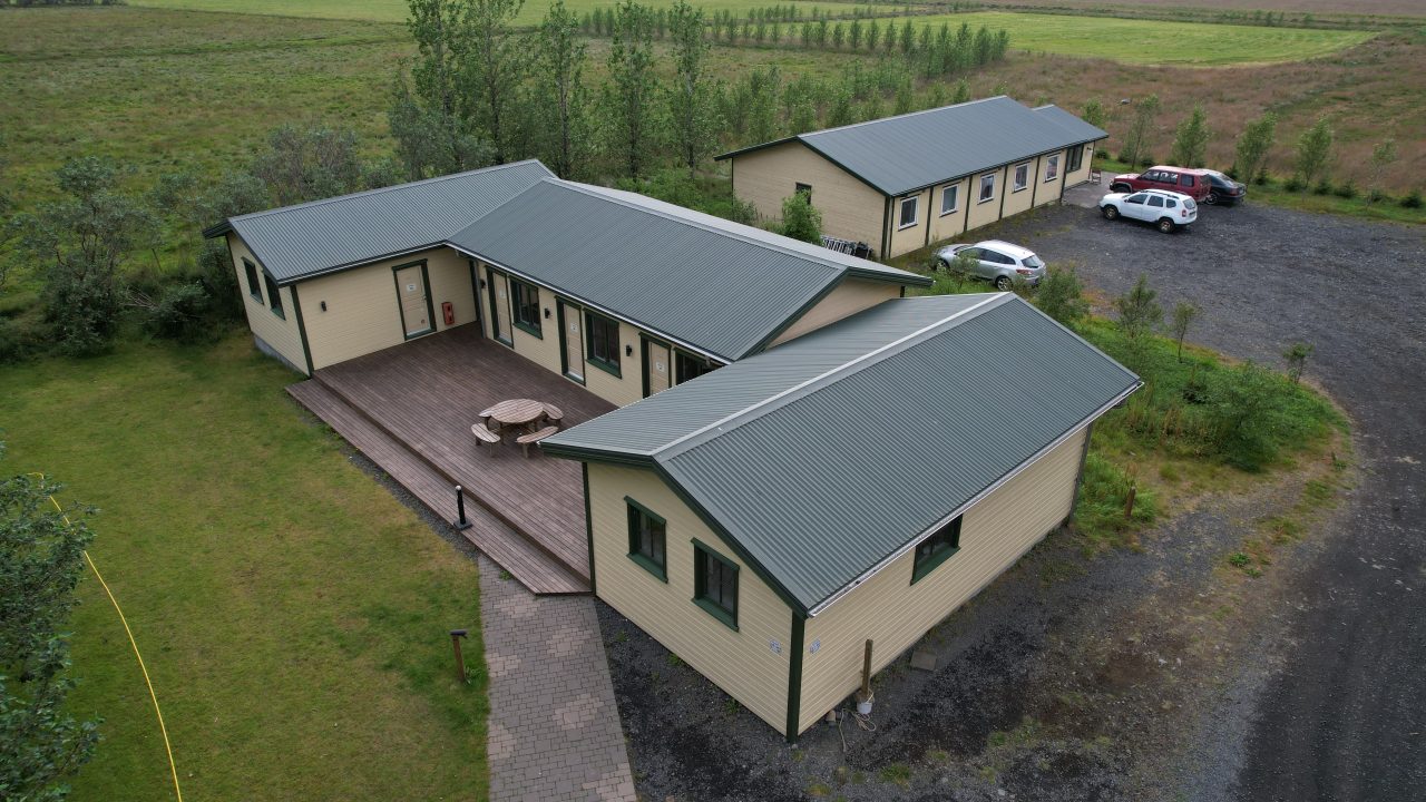 Aerial view of multiple single-storey hotel accommodation buildings arranged around shared outdoor areas.