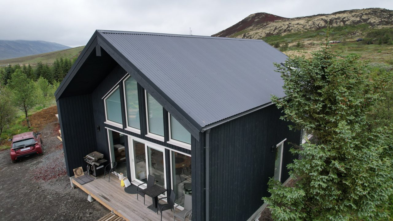 Side view of the VITA-84 timber house in Iceland showing the pitched roof and large glazed façade.