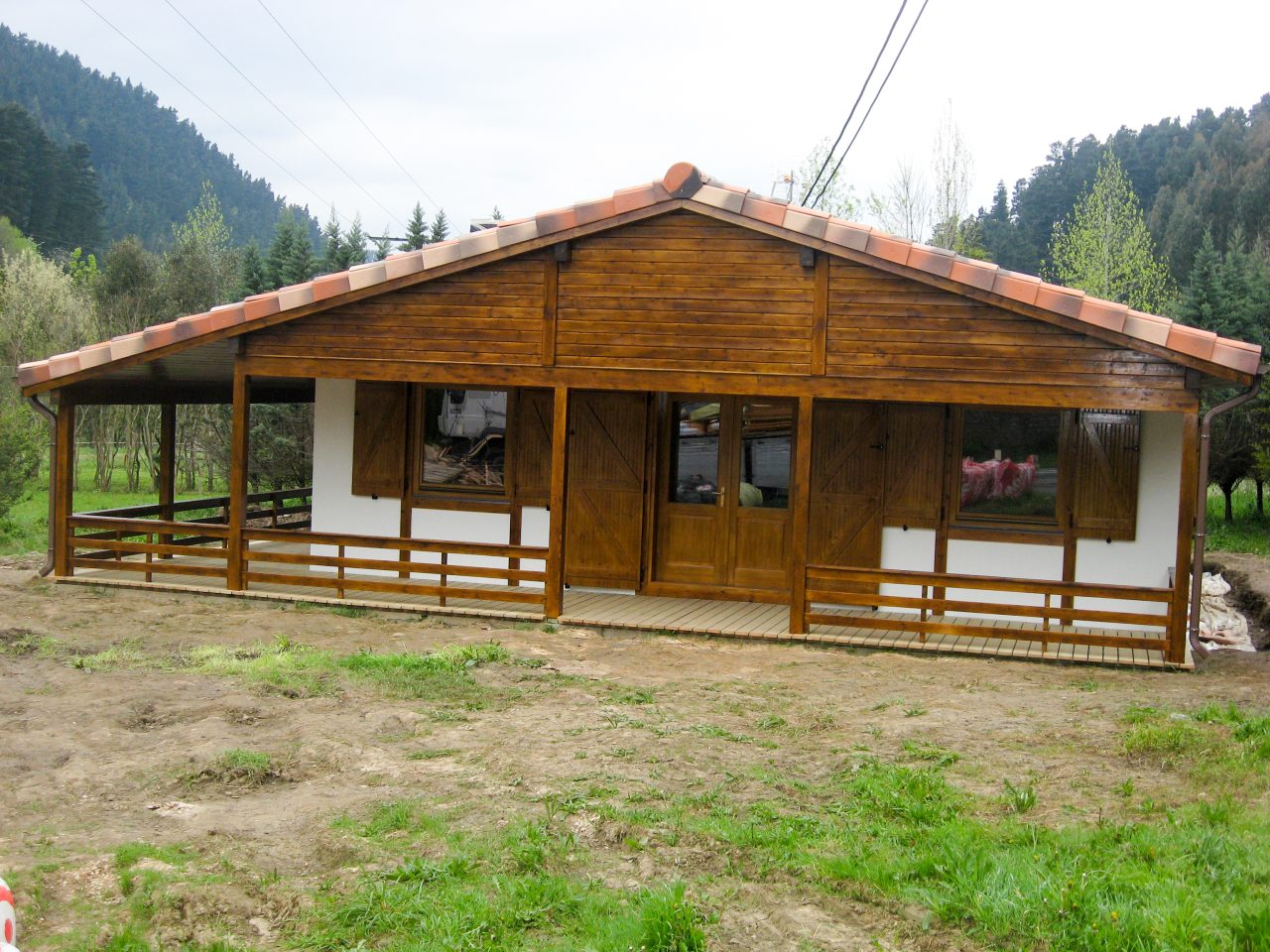 Front view of a single-storey timber house with wooden façade and porch.