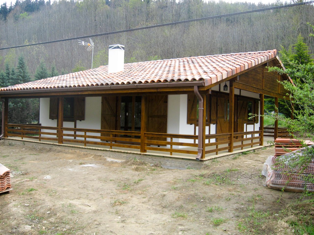 Single-storey timber house with tiled roof and covered veranda.