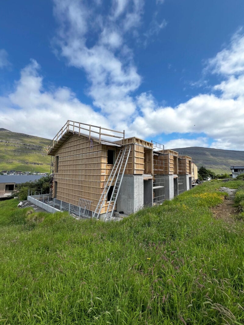 Timber-frame 3-apartment building under construction on a hillside in the Faroe Islands.